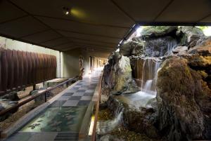 a indoor aquarium with a waterfall in a building at ABBA Resorts Izu - Zagyosoh in Ito