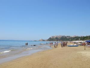 a group of people walking on a beach at Apartment Costa di Kair ed Din-3 by Interhome in Sperlonga
