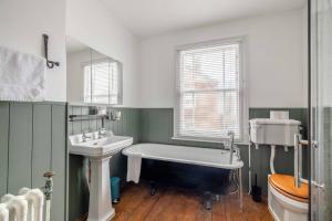 a bathroom with a bath tub and a sink at Stylish Home Central Windsor-Walk 2 All The Sights in Windsor