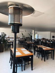 a restaurant with wooden tables and chairs and a lamp at Hotel Bertell Inn in Penedo