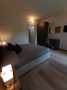 a bedroom with a large bed and a table with lights at Prealpina Hotel in Bagnolo Piemonte