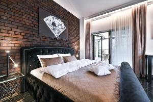 a bedroom with a large bed with a brick wall at Diamond svečių namai in Kaunas