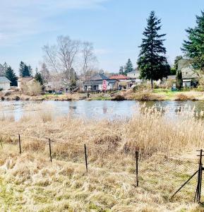 Un río con una valla delante de un pueblo. en Wasserspaß pur - Luxus Ferienhaus bei Berlin, direkt am Wasser, inkl SUPs und Schlauchboot!, en Oranienburg