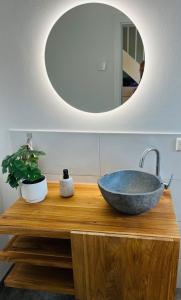 Un baño con un lavabo y un espejo. en Wasserspaß pur - Luxus Ferienhaus bei Berlin, direkt am Wasser, inkl SUPs und Schlauchboot!, en Oranienburg