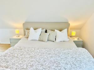 a white bed with white pillows and two lamps at Wasserspaß pur - Luxus Ferienhaus bei Berlin, direkt am Wasser, inkl SUPs und Schlauchboot! in Oranienburg