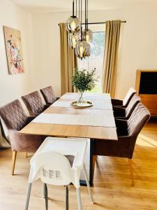 a dining room with a table and a couch at Wasserspaß pur - Luxus Ferienhaus bei Berlin, direkt am Wasser, inkl SUPs und Schlauchboot! in Oranienburg
