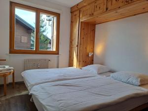 ein Schlafzimmer mit einem großen Bett und einem Fenster in der Unterkunft Apartment Galaxie 110 by Interhome in Verbier