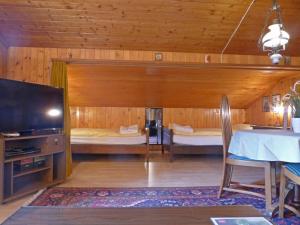 ein Wohnzimmer mit 2 Betten und einem TV in der Unterkunft Apartment Eigersonne by Interhome in Wengen