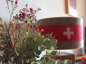 un vase avec des fleurs à côté d'une lampe dans l'établissement Apartment La Bercière 21 by Interhome, à Villars-sur-Ollon