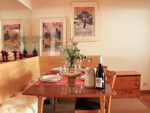 a dining room with a table with a bottle of wine at Apartment La Bercière 21 by Interhome in Villars-sur-Ollon