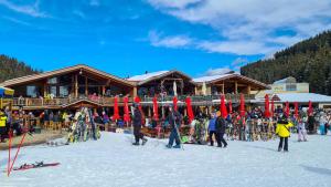 a group of people standing in the snow in front of a ski lodge at Studio with balcony, mountain view, 4* SPA Resort, Bansko in Bansko