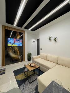 a living room with a couch and a tv at Sueño Apartments & Suites in Tirana