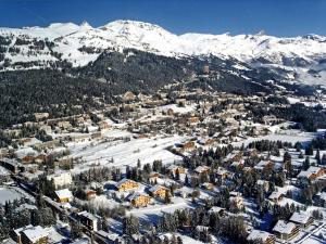 een luchtzicht op een stad met besneeuwde bergen bij Apartment Appart-Hotel Helvetia Intergolf by Interhome in Crans-Montana