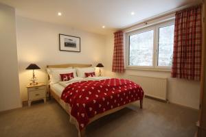 ein Schlafzimmer mit einem Bett mit einer roten Decke und einem Fenster in der Unterkunft Haus Salzkammergut in Obertraun