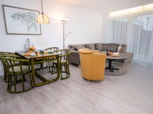 a living room with a couch and a table and chairs at Holiday Home Butzel by Interhome in Norddeich