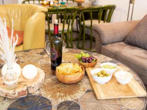 a table with a bottle of wine and bowls of food at Holiday Home Butzel by Interhome in Norddeich