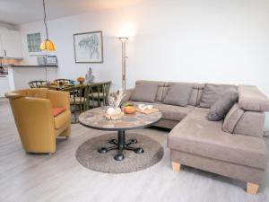 een woonkamer met een bank en een tafel bij Holiday Home Butzel by Interhome in Norddeich