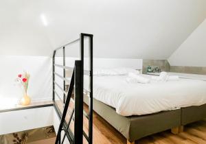 Un dormitorio con una cama grande con sábanas blancas. en Rainbow, rue carnot, en Annecy