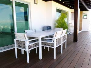 - une table et des chaises blanches sur une terrasse couverte dans l'établissement Dreams Room Soha II, à Santiago de los Caballeros