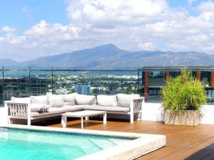 - un canapé blanc installé sur une terrasse à côté de la piscine dans l'établissement Dreams Room Soha II, à Santiago de los Caballeros