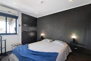 Un dormitorio con una cama grande con sábanas azules. en Apartamento Freire, en Portimão