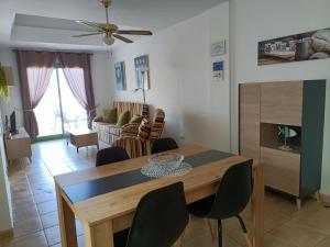 a living room with a dining room table with chairs at Estupendo Apartamento Gaudia in Caleta De Fuste