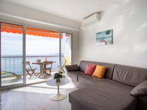 a living room with a couch and a view of the ocean at Apartment L'Angelina-1 by Interhome in Cros-de-Cagnes