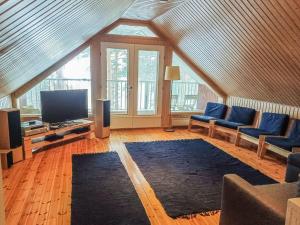 Il comprend un salon doté d'une télévision à écran plat et de chaises bleues. dans l'établissement Holiday Home Piilutupa by Interhome, à Luhanka 14 autres photos