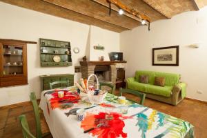 een woonkamer met een tafel en een groene bank bij Casale on the lake with sauna and saltwater swimming pool in Baschi