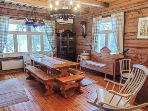 une salle à manger avec une table en bois et un piano dans l'établissement Holiday Home Piilutupa by Interhome, à Luhanka