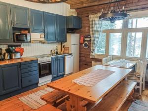 une cuisine avec des placards bleus et une table en bois dans l'établissement Holiday Home Piilutupa by Interhome, à Luhanka