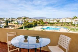 a table and chairs on a balcony with a view of a pool at Seaview terrace by the beach in El Faro Ref 93 in Mijas Costa