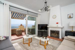 salon z kominkiem i widokiem na ocean w obiekcie Seaview terrace by the beach in El Faro Ref 93 w mieście Mijas Costa
