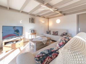a living room with a couch and a tv at Holiday Home Noordzeepark Zeewind 2-1 by Interhome in Mispelburg