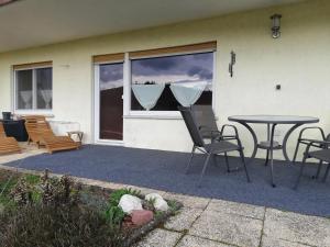 a patio with a table and chairs in front of a window at Ferienwohnung Klosterblick in Bastheim