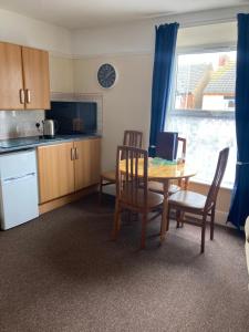 a kitchen with a table and chairs and a dining room at Happy Holiday apartments in Mablethorpe