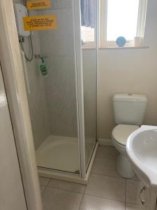 a bathroom with a shower and a toilet and a sink at Happy Holiday apartments in Mablethorpe