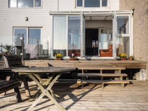 une terrasse en bois avec une table et des chaises devant une maison dans l'établissement Sunset Beach House By Air Premier, à Seaford