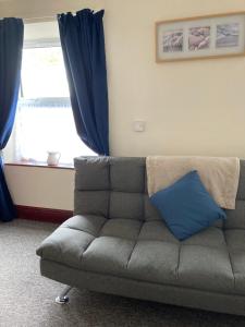 a couch with a blue pillow in a living room at Happy Holiday apartments in Mablethorpe