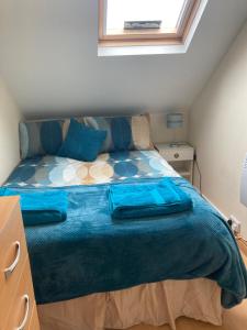 a bedroom with a bed with a blue blanket on it at Happy Holiday apartments in Mablethorpe