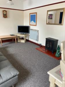 a living room with a couch and a television at Happy Holiday apartments in Mablethorpe