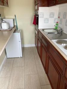 a kitchen with a sink and a white refrigerator at Happy Holiday apartments in Mablethorpe +15 photos