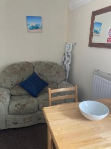 a living room with a couch and a table at Happy Holiday apartments in Mablethorpe