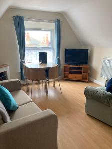 a living room with a couch and a table and a tv at Happy Holiday apartments in Mablethorpe