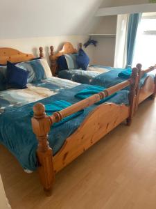 two twin beds in a bedroom with blue sheets at Happy Holiday apartments in Mablethorpe