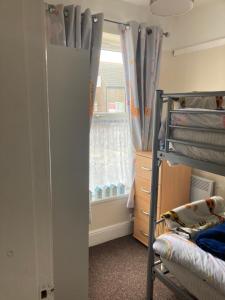 a bedroom with a bunk bed and a window at Happy Holiday apartments in Mablethorpe