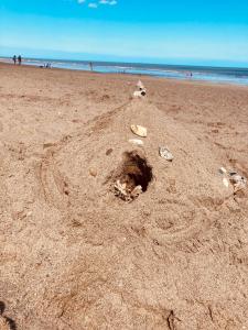 a sand castle on a beach with the ocean in the background at Happy Holiday apartments in Mablethorpe