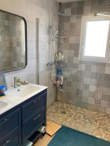La salle de bains est pourvue d'un lavabo et d'une douche avec un miroir. dans l'établissement La Villa Omaha YourHostHelper, à Marcheprime