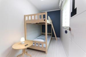 a bunk bed in a room with a desk and a table at Cobe Guesthouse Dongdaemun in Seoul