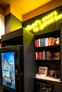 TV en una habitación con estantería para libros en The Wesley Camden Town, en Londres